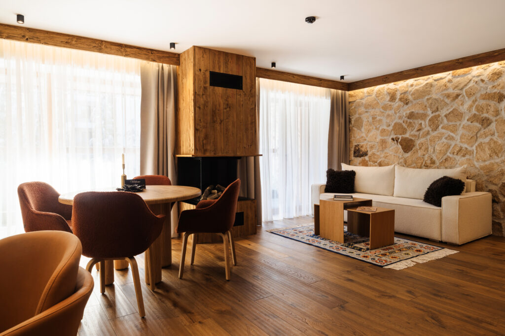 Chalet Prestige 215: living area with dining table and stone wall – Flora Boutique Hotel, hotel in Borovets